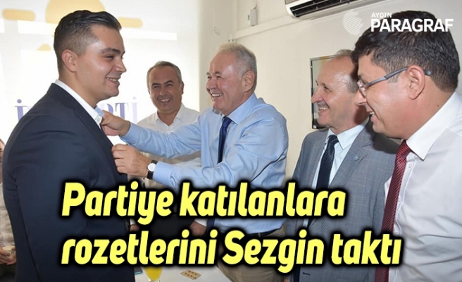 Partiye katılanlara rozetlerini Sezgin taktı