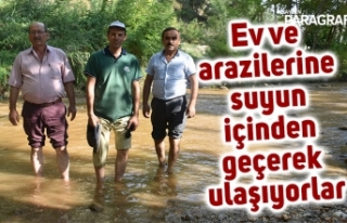 Ev ve arazilerine suyun içinden geçerek ulaşıyorlar