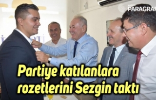 Partiye katılanlara rozetlerini Sezgin taktı